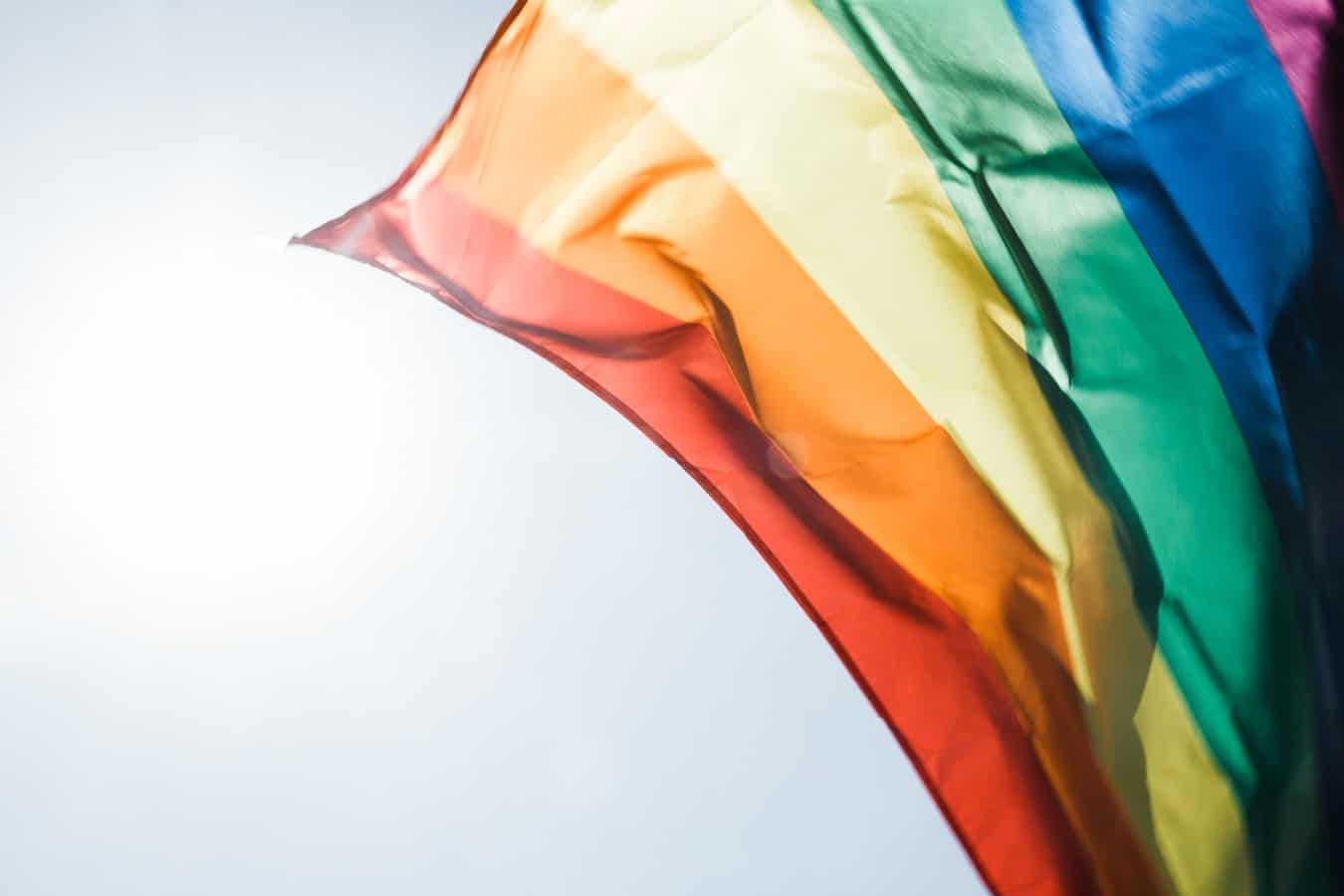 rainbow flag on blue sky background